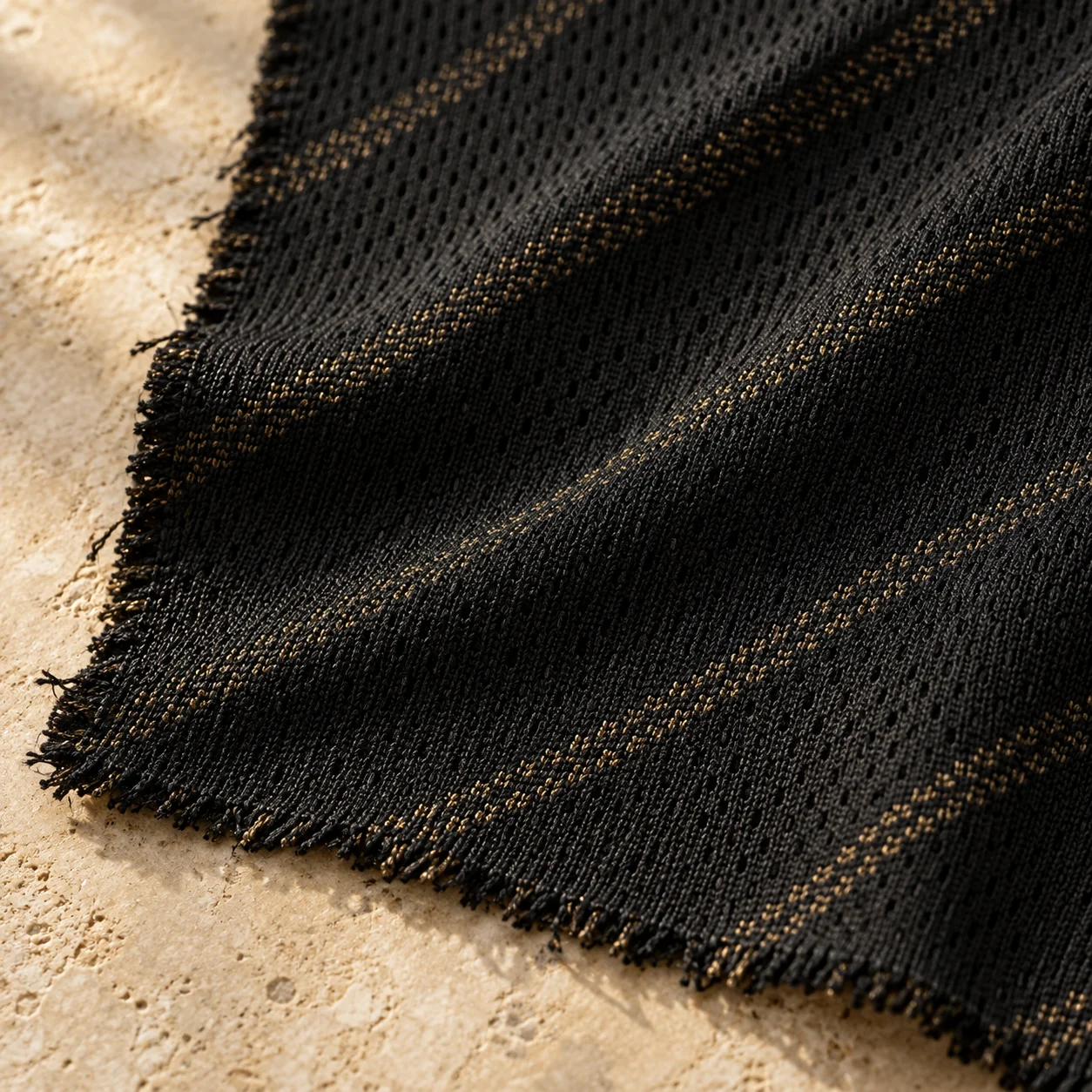 Close-up of black football knit fabric with subtle gold threads