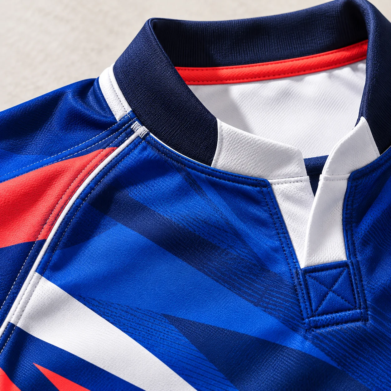 Close-up of reinforced blue, white and coral rugby collar and shoulder seams