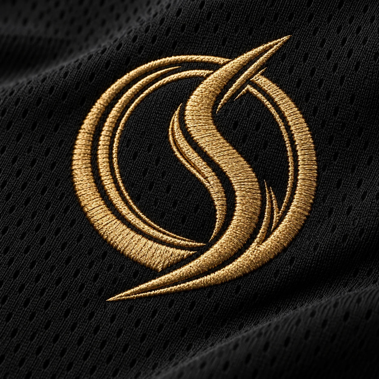 Gold embroidered Oversky concept emblem integrated into black jersey fabric